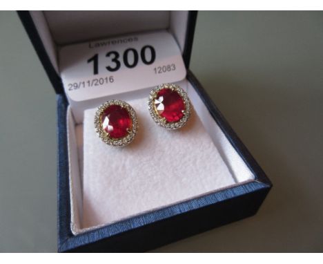 Pair of yellow gold oval treated ruby and diamond cluster ear studs