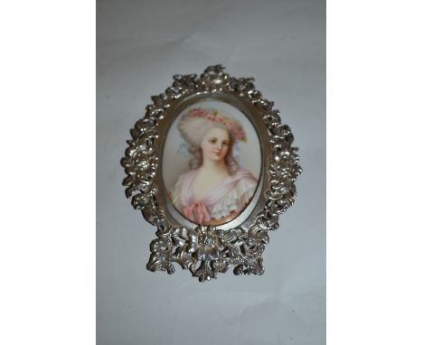 Small Continental silver oval floral design frame housing a miniature portrait on porcelain of a lady, makers mark B.M. (Bern