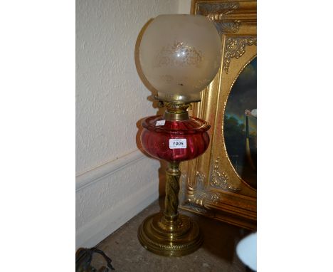 Victorian gilt brass oil lamp with a cranberry glass well and an etched glass shade