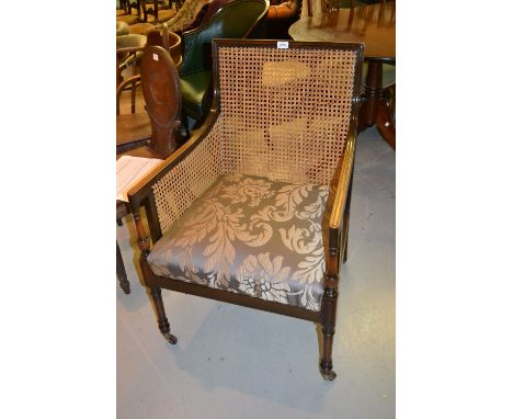 Edwardian mahogany Bergere armchair in Georgian style with upholstered seat, raised on turned front supports with brass and c