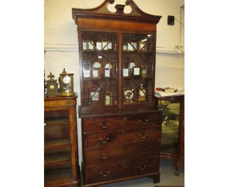 George III mahogany bookcase, the blind fretwork cornice above two astragal glazed doors, the base with four drawers with bra