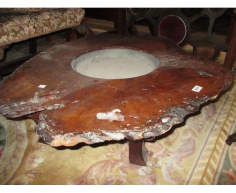 Japanese hibachi formed from a tree trunk cross section and raised on splay supports, together with a cast iron kettle
