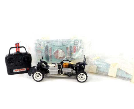 A Kyosho Nitro remote control car, with remote, and two sets of plastic bodies with Vauxhall decals, etc.