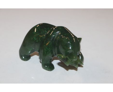 A carved jade coloured ornament in the form of a bear, signed to base 