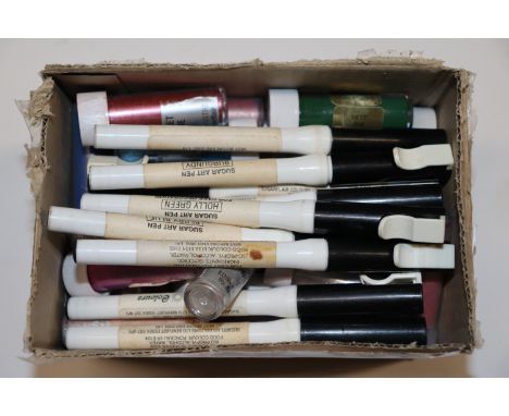 A box containing sugar art pens and edible lustre for cake decorating