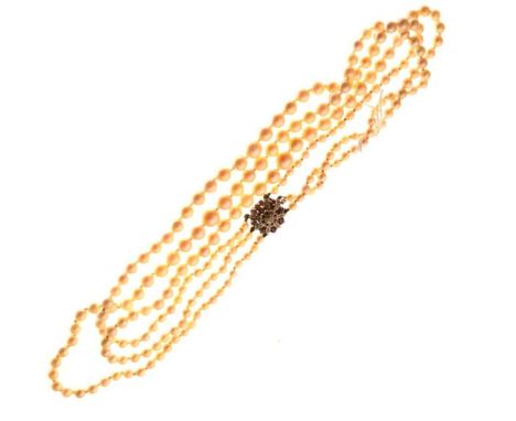 Three-row graduated cultured pearl necklace to a diamond and ruby clasp, unmarked, the largest pearls 8mm approx