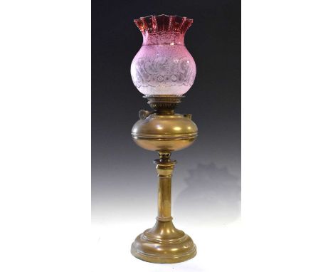 Oil lamp having cranberry shade, 63cm high