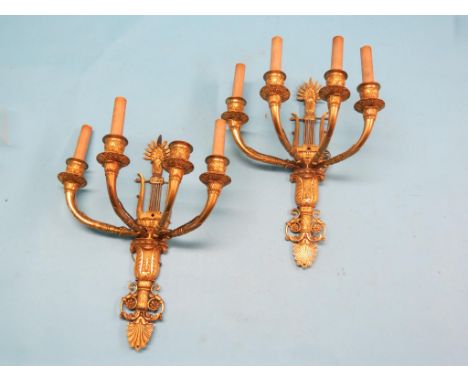 A pair of 19th century brass four-light wall sconces, cast with lyres, anthemion and other classical devices, 15in.