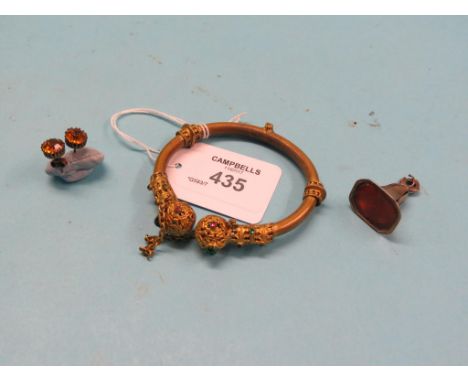 A jewelled brass bangle, gold-coloured seal, and a pair of claw-set ear-studs 