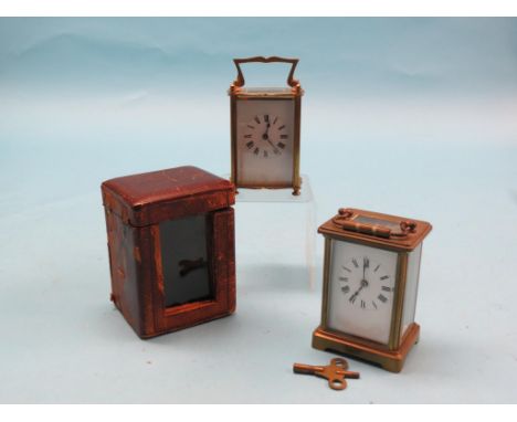 A brass carriage clock, enamelled dial and timepiece movement, personalised and dated 1918, in original leather case, and one