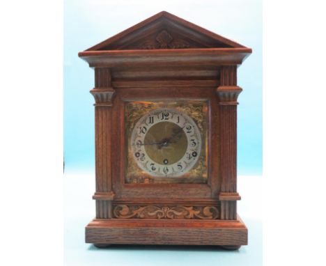 A late 19th century oak mantel clock, architectural form with square brass dial, German chiming movement, with key and pendul