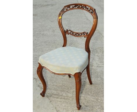 A Victorian walnut balloon back dining chair with pierced decoration, retailers label for T R Roberts, and a mahogany balloon