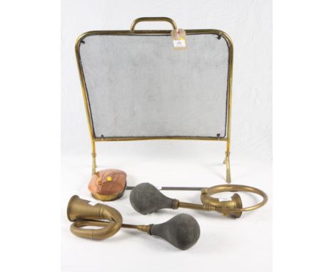 A brass firescreen, two brass car horns, a brass balance and a copper chestnut roaster