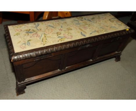 An oak box seat ottoman with three panel front and tapestry seat panel, 39" long, and a two-tier tea trolley, on spiral turne