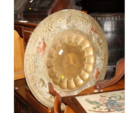 An Indian brass tray with dished centre and folding wooden stand, 30" dia, and an early 19th Century wall mirror with half ro