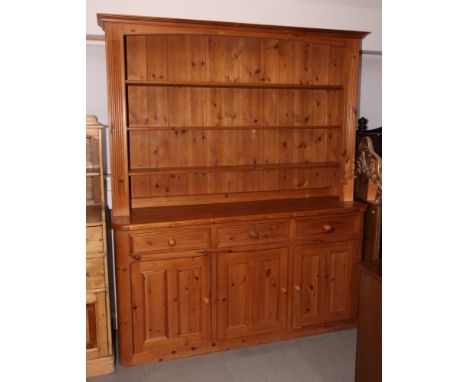A pine dresser with boarded three-shelf back, base fitted three drawers and cupboards, 70" wide x 84" high