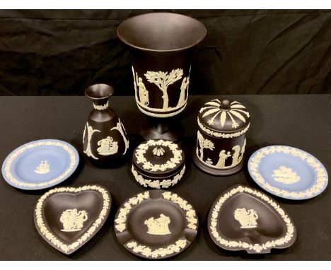 A Wedgwood black Jasperware pedestal vase, cylindrical jar and cover, vase, other blue and black Jasperware trinket dishes (9