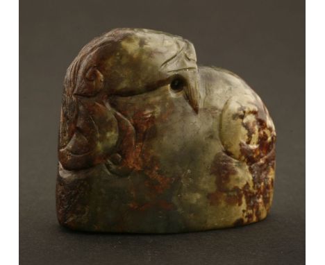 A Chinese jade carving,late Qing dynasty, of a ram, the stone in spinach green and russet oxidation, the base carved with arc