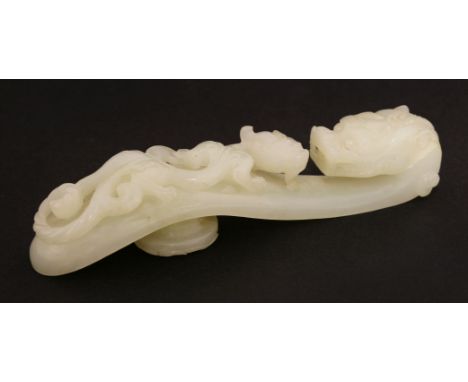 A Chinese jade belt hook,Qianlong (1736-1795), of typical form, one end with a dragon's head, the other with a chilong climbi