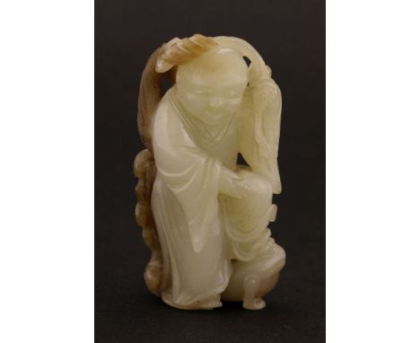 A Chinese jade carving,late Qing dynasty, of Liu Hai, standing with his left foot on a toad, his left arm raised with a chain