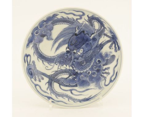 A Chinese blue and white dish,Yongzheng (1723-1735), painted with a dragon grasping a flaming pearl amongst clouds, the under