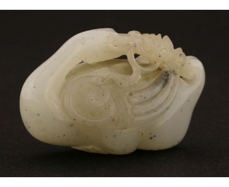 A Chinese jade carving,late Qing dynasty, of a goose holding a lotus stem in its mouth, the detail of its wings engraved with