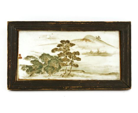 A Japanese ceramic plaque, late 19th century, painted with trees by a river under moonlight, mountains afar, signature and bo