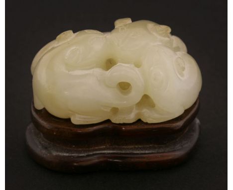 A Chinese jade carving, late Qing dynasty, of three badgers leaning close to each other, the stone in an even pale green tone