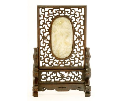 A Chinese table screen, 19th century, pierced and carved with scrolls on ruyi head shaped supports, inset with a jade plaque 