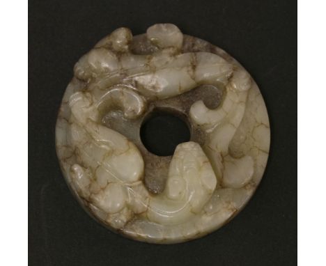 A Chinese jade bi disc,Ming dynasty (1368-1644), of circular form carved with a chilong, the underside with archaic studs,4.7