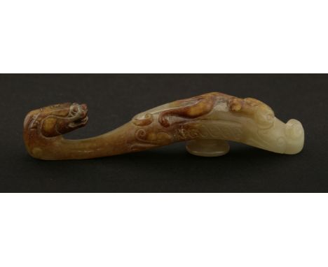A Chinese jade belt hook,Yuan dynasty (1279-1368), of typical form, one end with a dragon's head, the other with a chilong cl