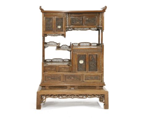 A Chinese display cabinet,early 20th century, each door of cupboards and drawers carved with precious objects, two of them in