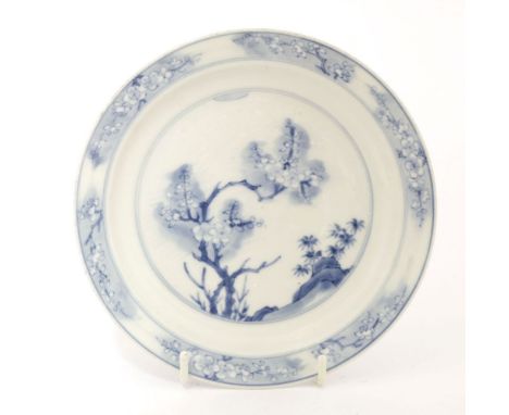 A Chinese blue and white dish,Kangxi (1662-1722), of circular form with stepped side, painted with blossoming prunus branches