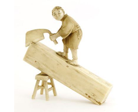 A Japanese ivory okimono,Meiji period (1868-1912), of a carpenter standing on a section of log propped up by a stool, hacking