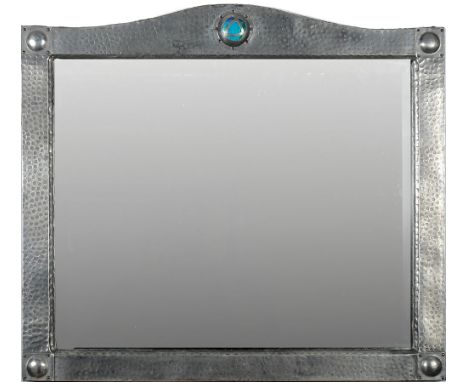 A Liberty style hammered pewter wall mirror: of arched outline with enamel boss to the central arch and plain bosses to each 