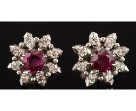A pair of ruby and diamond circular cluster ear-studs: each with a central round ruby approximately 5.0mm. diameter, claw-set