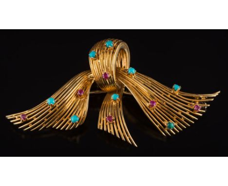 A turquoise and ruby mounted stylized bow brooch: highlighted with circular turquoise and rubies, 7.3cm total length of brooc