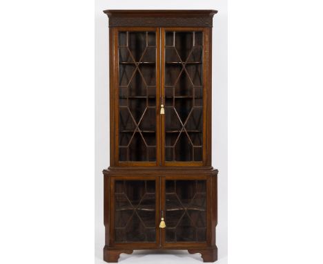 An Edwardian mahogany standing corner display cabinet:, in two parts, the upper part with a moulded cornice and blind fret ca