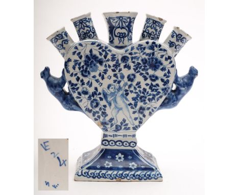 A Dutch blue and white delftware tulip vase: the heart shaped body with five nozzles and crouching leopard handles, painted w