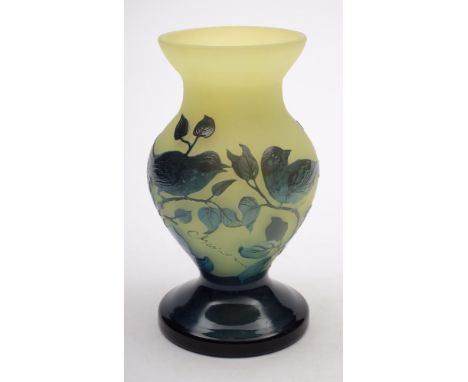 A French cameo glass vase: of footed baluster form, the light green body with glossy blue green overlay  depicting a pair of 