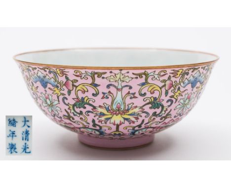 A Chinese porcelain bowl: the exterior decorated in the famille rose palette with lotus and peony scroll reserved on a pink g