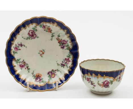 A Worcester fluted tea bowl and saucer: painted with floral swags below a royal blue border, circa 1775, diameter of saucer 1