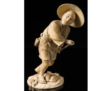 A Japanese sectional ivory okimono: Meiji period (1864-12) of a peasant wearing traditional clothes holding a bamboo stick (t