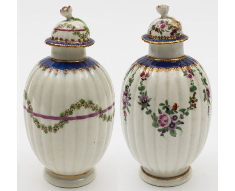 Two Worcester tea canisters and covers: both of reeded ovoid form with flower finials and gilded royal blue borders, one pain