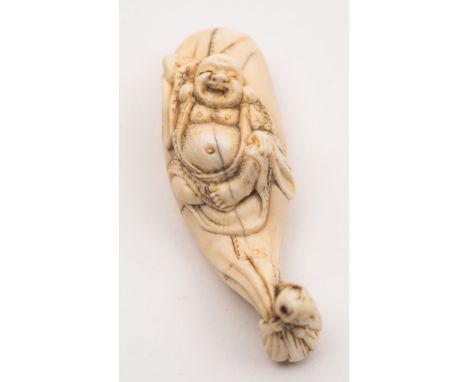 A Japanese carved ivory netsuke, signed Yasuhide kore wo koku [Yasuhide carved this]: of Hotei lying in his bag being pulled 