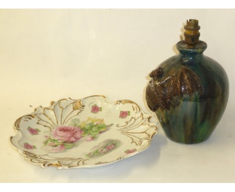 A STUDIO POTTERY TABLE LAMP EMBOSSED WITH A BAT AND A CHINA PRINTED WALL PLAQUE WITH ROSES (2) 