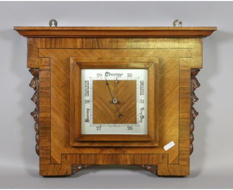 An Art Deco crossbanded mahogany cased wall barometer with carved mouldings.