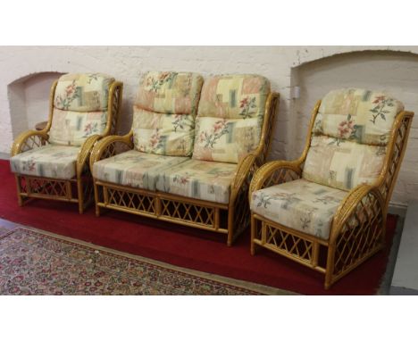 A bamboo and cane three piece conservatory suite comprising two armchairs and a two seater sofa.