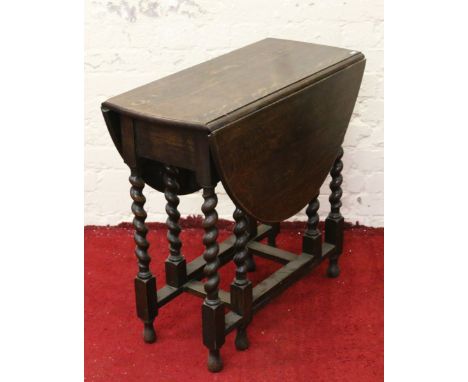 A small oak gate leg table raised on barleytwist supports.