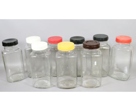 Nine vintage glass sweet jars with plastic covers.